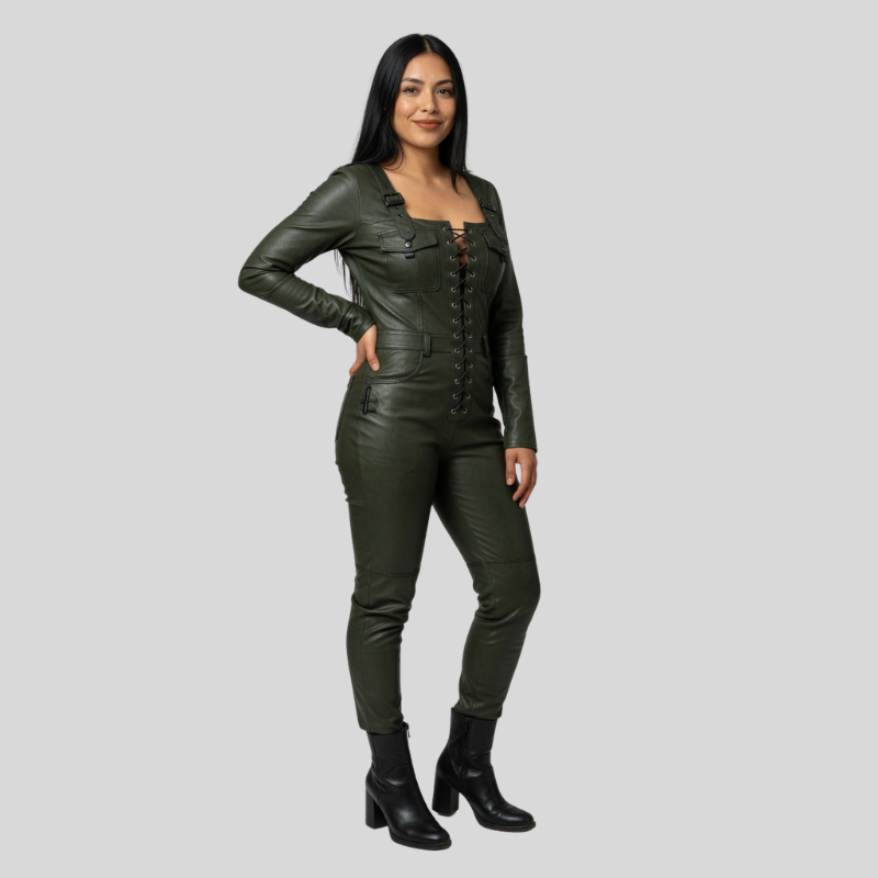 A woman modeling a dark olive green leather jumpsuit with a lace-up front and matching slim-fit pants, paired with black ankle boots, against a solid light gray background.
